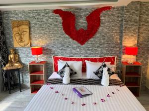 
a hotel room with a bed, lamps, and nightstand at Fong Kaew and Baan Nang Fa Guesthouse in Patong Beach
