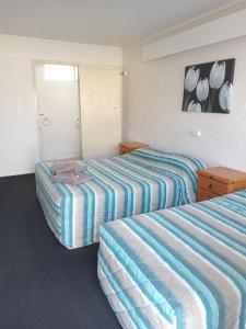 two beds in a hotel room with two bedsvisor at Millmerran Motel in Millmerran