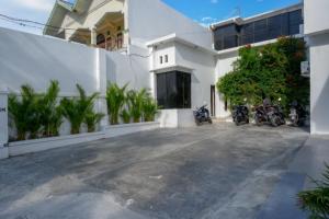 un edificio blanco con motocicletas estacionadas fuera de él en RedDoorz Plus @ Cameloan Hotel Palu en Palu