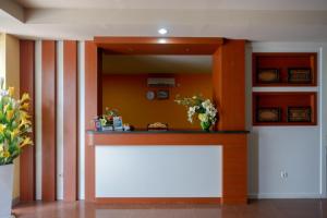 a lobby with a counter and a large mirror at RedDoorz Plus @ Cameloan Hotel Palu in Palu