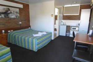 a hotel room with a bed and a kitchen at Millmerran Motel in Millmerran
