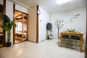 福冈Fukuoka Condominium的房间里有一张桌子，墙上挂着一个钟