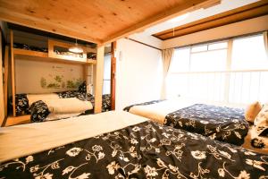 福冈Fukuoka Condominium的一间有两张床和一扇大窗户的卧室