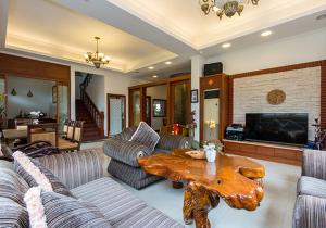 a living room with couches and a wooden coffee table at GuiZhuLin B&B in Jiaoxi