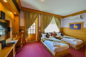 a hotel room with two beds and a television at Shwe Kyun Hotel in Taunggyi