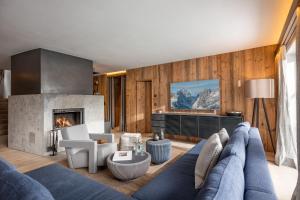 a living room with a blue couch and a fireplace at Chalet Ellmau in Ellmau