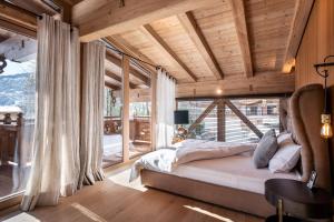 a bedroom with a bed and a large window at Chalet Ellmau in Ellmau