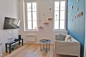 a living room with a couch and a tv at APPARTEMENT NEUF HYPER CENTRE _ SAINT FERREOL in Marseille