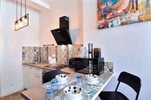 uma cozinha com uma mesa com cadeiras e um micro-ondas em APPARTEMENT NEUF HYPER CENTRE _ SAINT FERREOL em Marselha