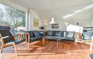 ØhuseにあるBeautiful Home In Ulfborg With Kitchenのリビングルーム(黒いソファ、椅子付)