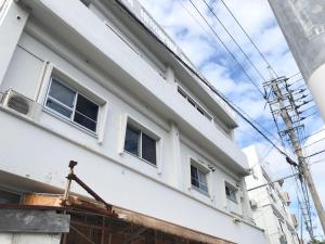 ein an der Seite eines Gebäudes errichtetes Gebäude in der Unterkunft SMILE ONE GUEST HOUSE OKINAWA in Yomitan