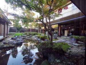 einen Garten mit einem Teich vor einem Gebäude in der Unterkunft Sakahijiri Nikko in Nikko