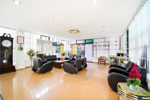 a waiting room with couches and tables and a clock at Super OYO 89486 Kulim Inn in Kulim