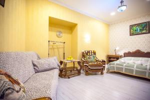 a bedroom with a bed and a couch and a chair at Guest House Happy Holidays in Tbilisi City