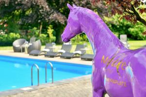 a pink horse standing in front of a pool of water at Mercure Aachen Europaplatz in Aachen