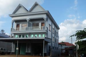 - un bâtiment blanc avec un balcon dans une rue dans l'établissement Mondulkiri Holiday homestay, à Saen Monourom