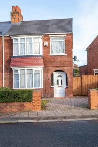 a red brick house with a white door at Alphalink house in Middlesbrough