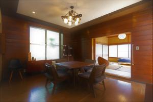 a dining room with a table and chairs at Cozy Villa with Hot springs and Nature in Ito