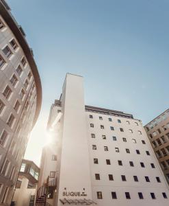 a tall white building in a city at Blique by Nobis, Stockholm, a Member of Design Hotels™ in Stockholm