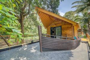 a small wooden cabin with a roof on top at Coconut Beach Farm in Alibaug