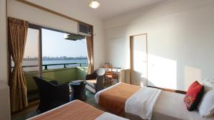 a hotel room with two beds and a balcony at Sea Green Hotel in Mumbai
