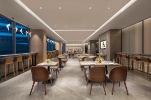 Un restaurante con mesas y sillas en una habitación. en Citadines Songshan Lake Dongguan, en Dongguan
