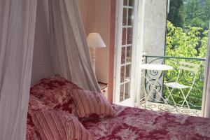 a bedroom with a bed next to a window at Hostellerie Belle Rive in Gagnac-sur-Cère