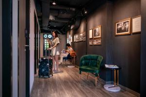 a woman standing in a hallway with a child sitting in a chair at ST Signature Chinatown in Singapore