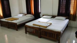 two beds sitting in a room withskirts at Coral Homes in Cochin