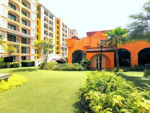 a lawn in front of a building with palm trees at D14 Venetian Condo Resort Pattaya Pool Connected Netflix in Jomtien Beach
