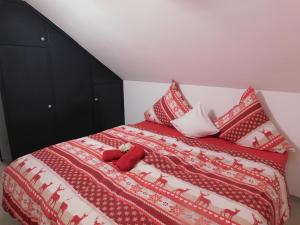 ein Schlafzimmer mit einem Bett mit roten und weißen Decken und Kissen in der Unterkunft Haus Astenblick in Winterberg für bis zu 35 Personen für Wanderveranstaltungen und Familienfeiern in Winterberg