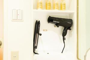Hotel LOVE JEWEL في كيتاكيوشو: مجفف شعر معلق على الجدار في الحمام