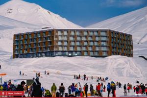 a group of people in the snow in front of a building at New Gudauri Atrium 335 in Gudauri