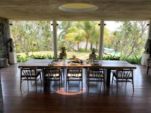 ein Esszimmer mit einem Holztisch und Stühlen in der Unterkunft Villa Palem in Tabanan