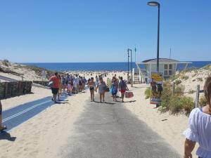 a crowd of people walking down the beach at Blue Ocean in Moliets-et-Maa
