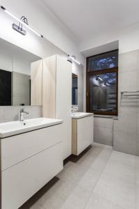 a white bathroom with a sink and a window at Martin Boutique Hotel in Plauen