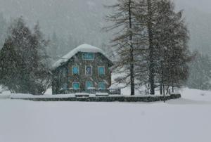 une maison recouverte de neige dans une tempête de neige dans l'établissement Il Cortese, à Chiareggio