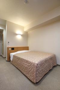 Postel nebo postele na pokoji v ubytování Best Inn Uozu