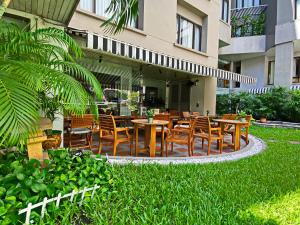 een restaurant met houten tafels en stoelen voor een gebouw bij Silom Serene A Boutique Hotel - SHA Extra Plus in Bangkok