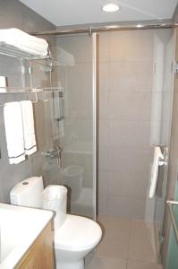 a bathroom with a toilet and a glass shower at York Hotel in Taipei