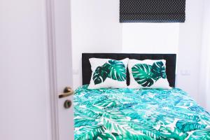 1 dormitorio con 1 cama con manta verde y almohadas en Holiday House Apartament 95m2 Deptak Bogusława, en Szczecin