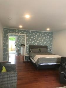 a bedroom with a bed and a wall with flowers at ROTORUA EASTSIDE APARTMENTS in Rotorua