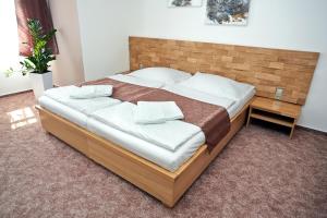 ヴァラシュスケー・メジジーチーにあるVila Encoreのベッドルーム1室(大型ベッド1台、木製ヘッドボード付)