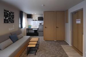 a living room with a couch and a kitchen at Koti Sopo Universal Bay 1 by Liaison in Osaka