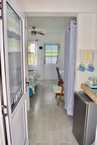 une cuisine avec une porte s'ouvrant sur un salon dans l'établissement The Green Palm Cottage, à Plettenberg Bay