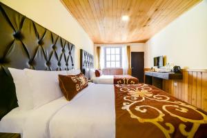 ein großes Schlafzimmer mit 2 Betten und einer Küche in der Unterkunft Summit Khangri Karpo Retreat & Spa in Lachung