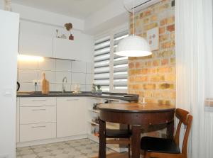 a kitchen with a wooden table and a brick wall at Nijole ir Algimantas in Anykščiai