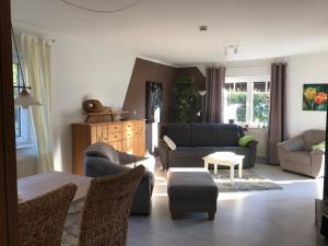 a living room with a couch and chairs and a table at Zuhause Woanders - Kuhtrade in Wildeshausen