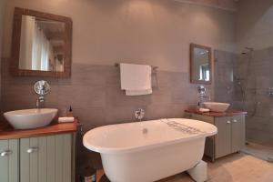a bathroom with a tub and a sink and a mirror at Salt Water House in Paternoster +31 photos