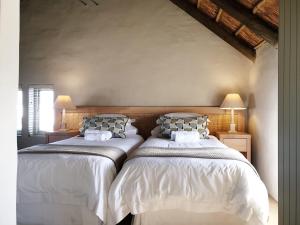 two beds sitting next to each other in a bedroom at Salt Water House in Paternoster